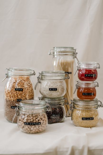 Clear glass jars with airtight lids containing various dry ingredients and preserved foods