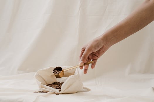 极简主义的设置中，勺子将咖啡豆盛于白色织物之上，唤起了零浪费的主题