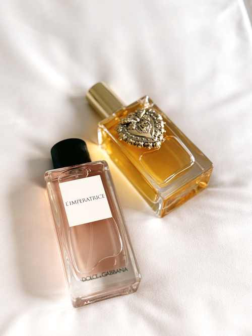 Free Close-up of two elegant perfume bottles on soft white fabric. Stock Photo