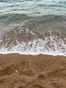 Calm waves gently lap at the sandy shore of the Adriatic Sea, capturing a peaceful coastal moment.