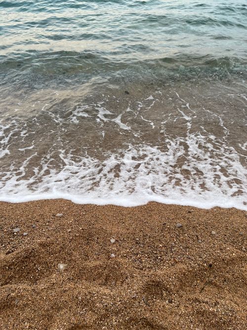 Free Calm waves gently lap at the sandy shore of the Adriatic Sea, capturing a peaceful coastal moment. Stock Photo