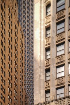Detailed view of ornate skyscraper facades in New York City, highlighting architectural contrast and urban design.