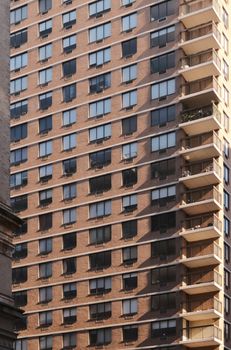 Close-up view of an urban high-rise building facade featuring balconies and geometric windows.