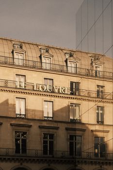 A classic view of the Louvre's architectural facade under warm evening light, capturing detail and elegance.