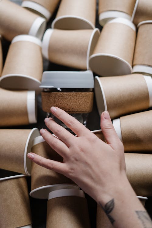 Person Holding Brown And White Paper Cups