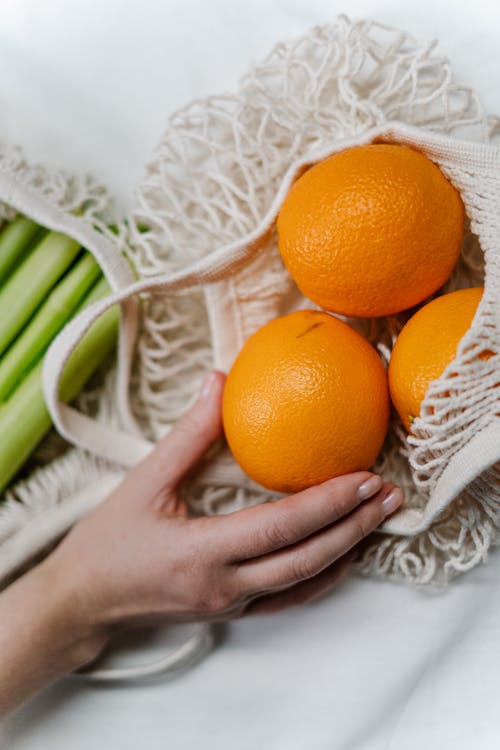 Persona In Possesso Di Frutta Arancione