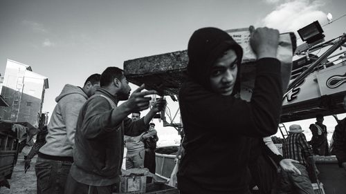 Free Dynamic black and white photo capturing city workers engaged in manual labor on a busy street. Stock Photo