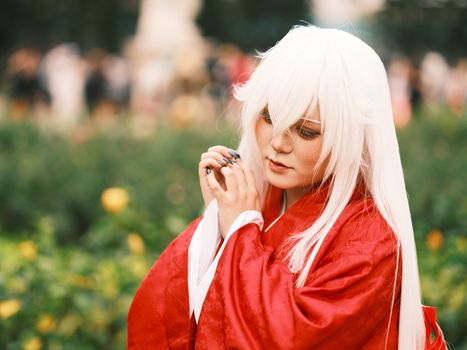 Captivating portrait of a cosplayer in a red kimono, adorned with white wig in Việt Nam.