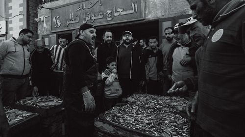 Free A bustling fish market scene with a crowd of people inspecting fresh seafood. Stock Photo