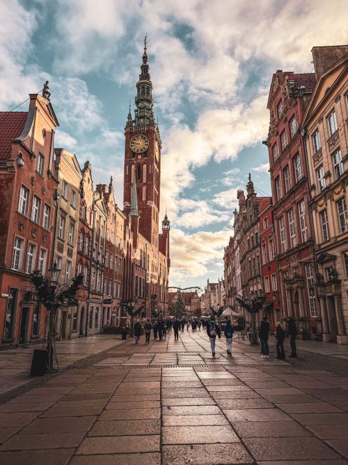 Free Beautiful street view of Gdańsk with the historic Main Town Hall under a vibrant sky. Stock Photo