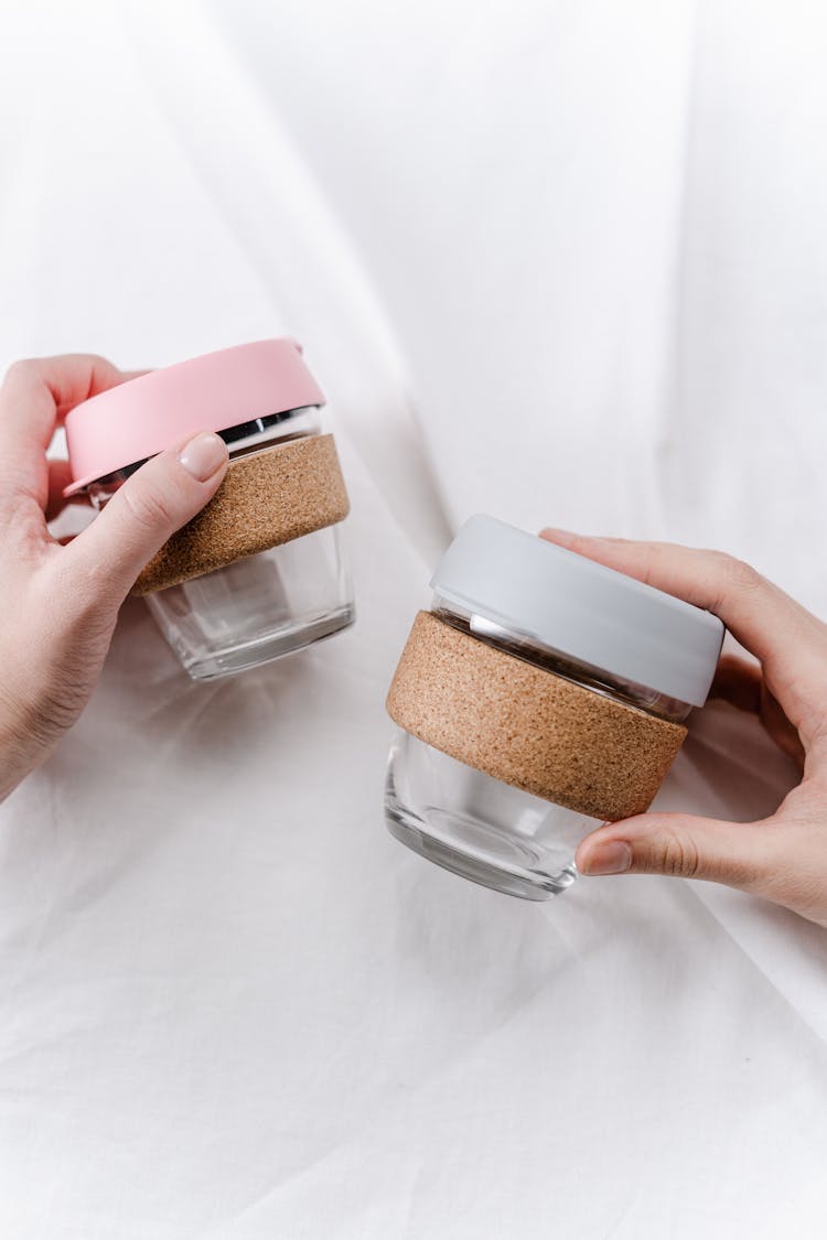 Person Holding Pink And Brown Plastic Containers