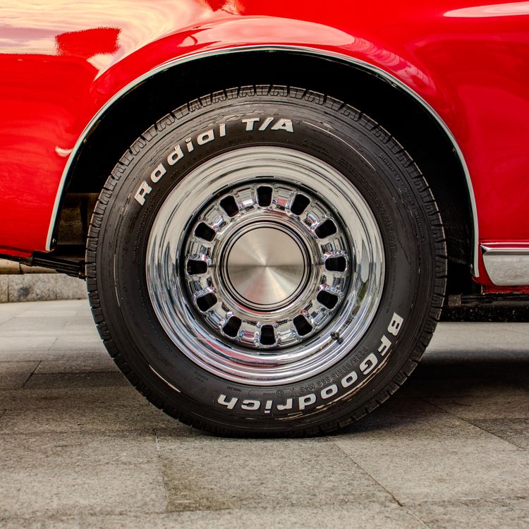 Close-up of Vintage Car Wheel with Chrome Rim · Free Stock Photo