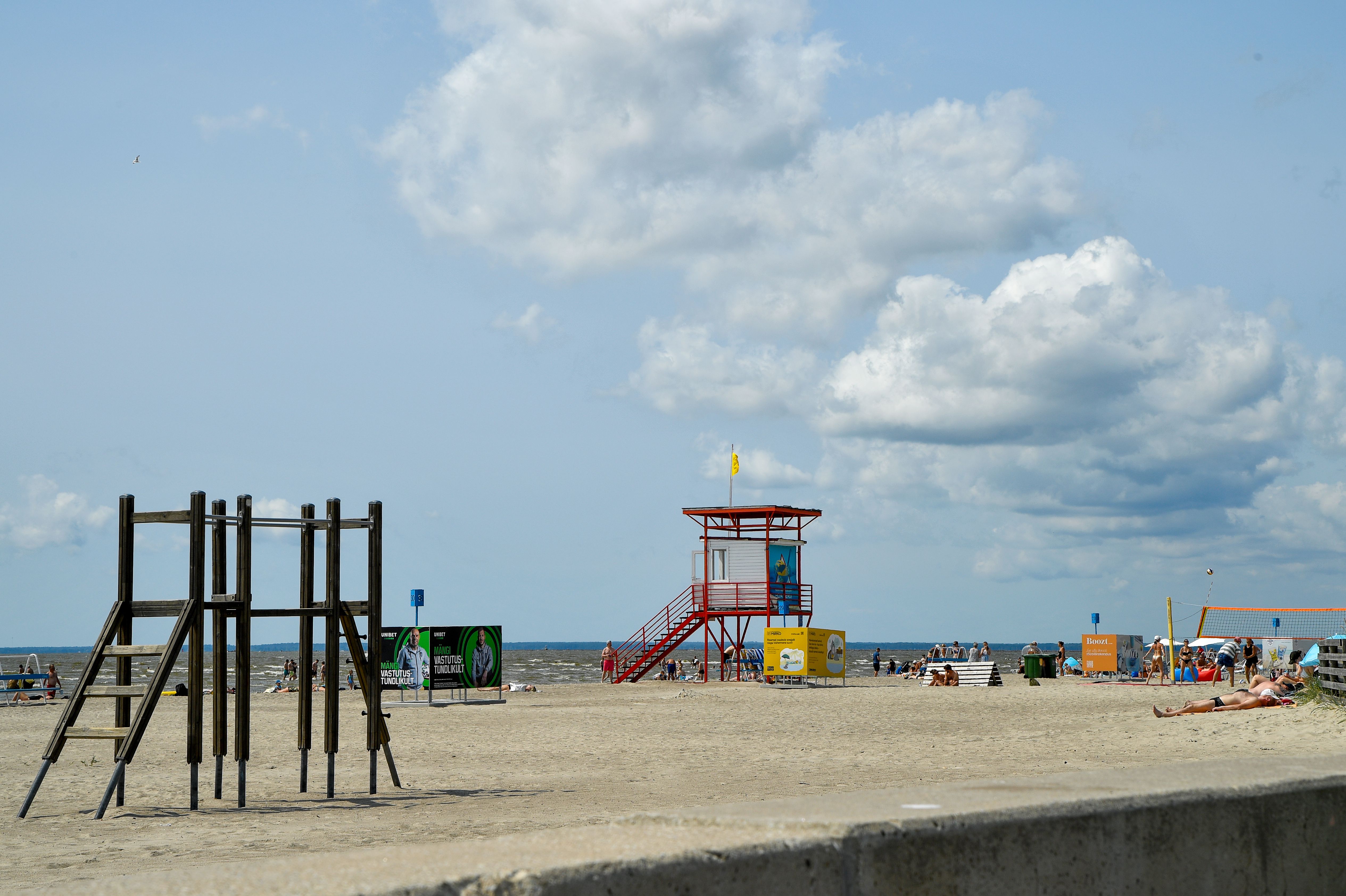 Relaxing summer day at Pärnu Beach with sandy shores and vibrant lifeguard tower.