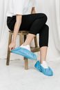 Person in White T shirt and Black Pants  Sitting on Brown Wooden Stool