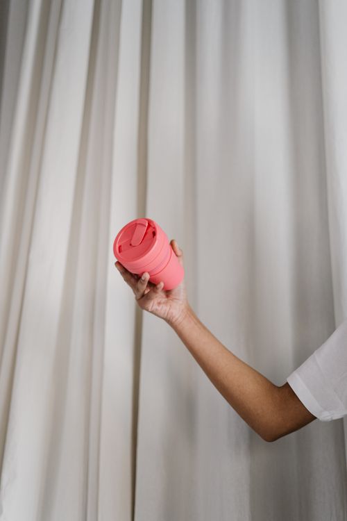 Free A person holding a pink reusable tumbler promoting eco-friendly, zero waste lifestyle. Stock Photo