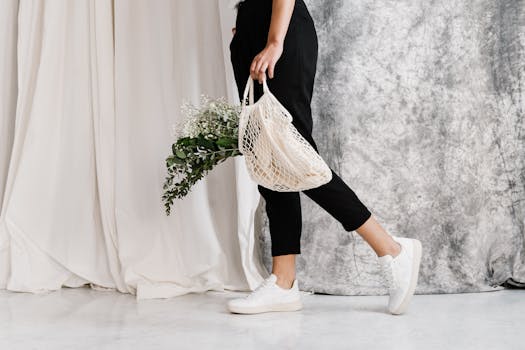 一位身着简约服装的女子，手持装满鲜花的环保网眼袋，展示着可持续的时尚