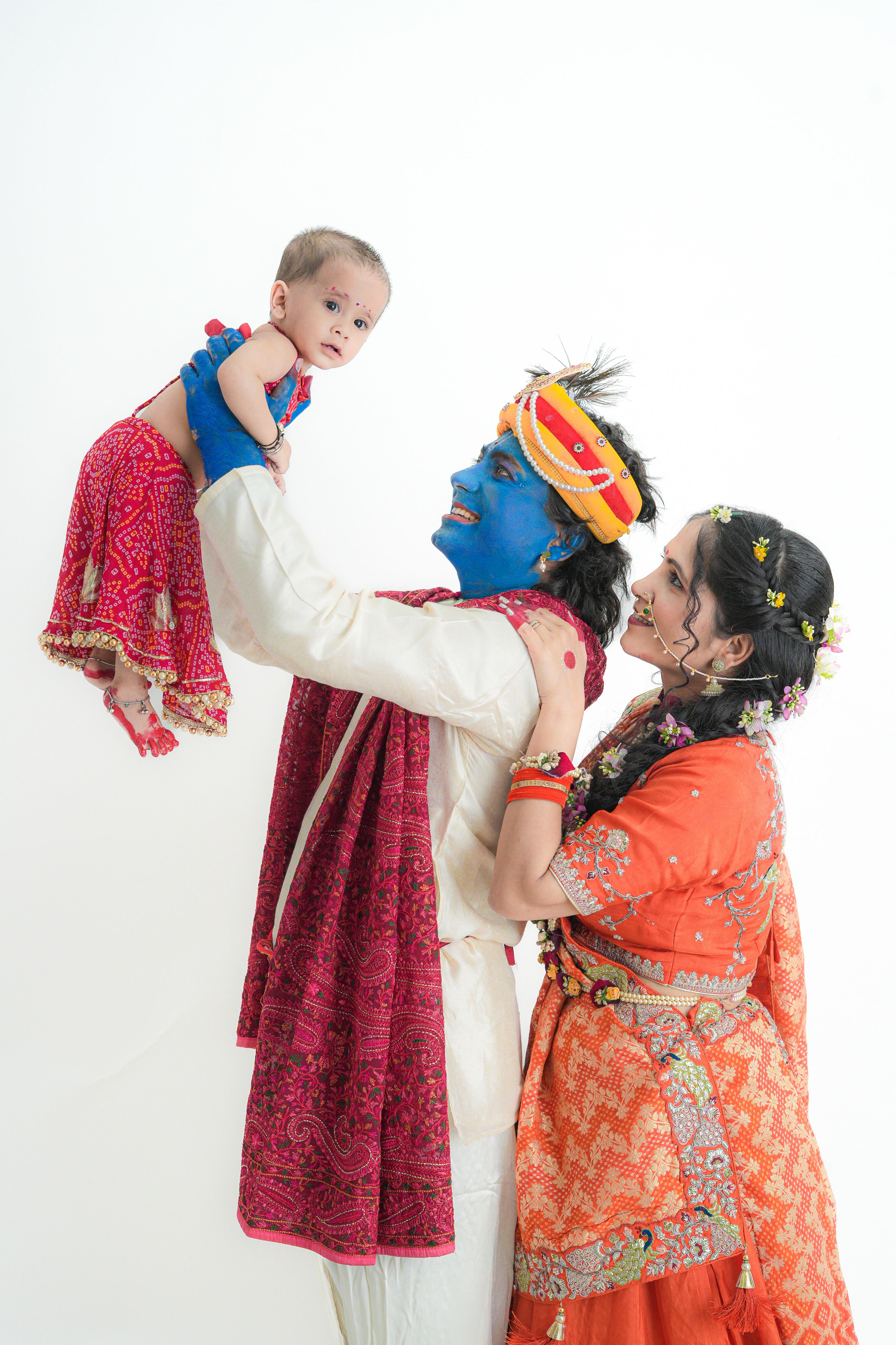 Indian family dressed in Krishna theme, embracing traditional culture and joy.