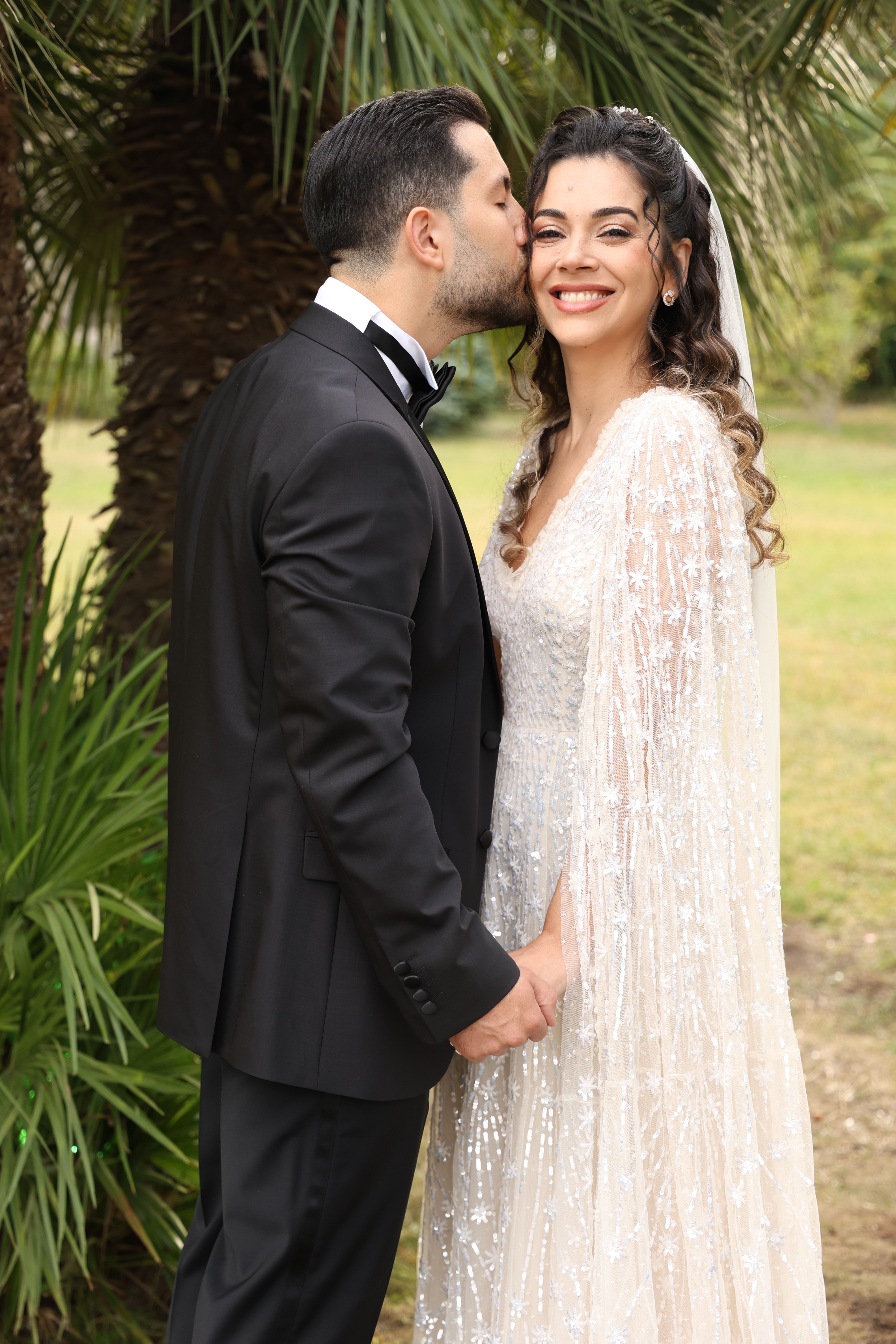 Bride and groom sharing a romantic moment in a garden setting.