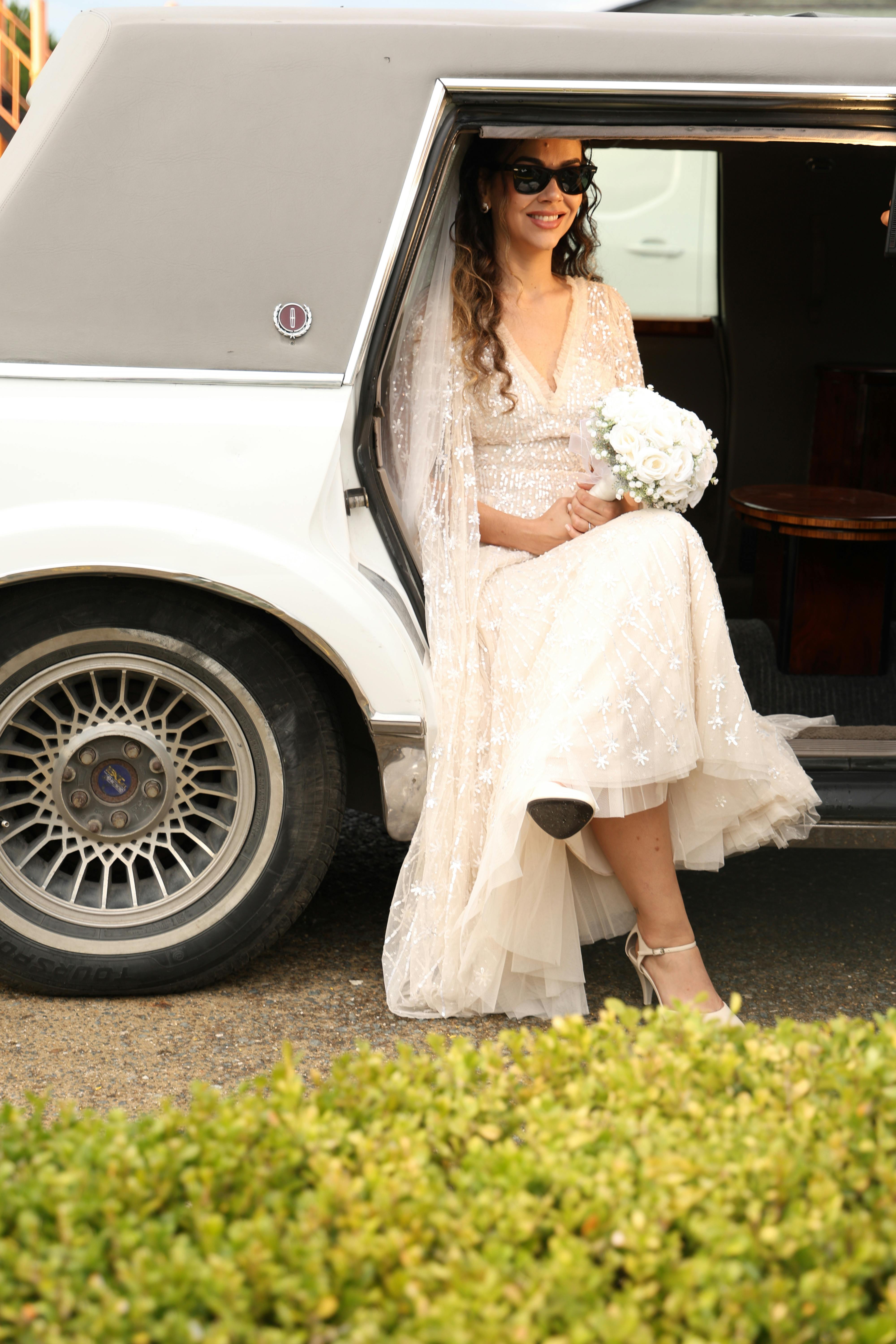 Bride in white dress stepping out of Toronto wedding limo service vehicle