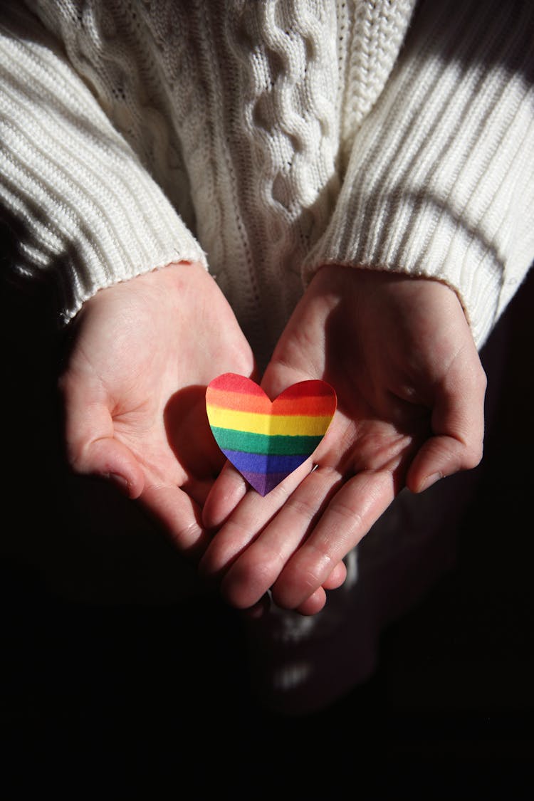 Person Holding Multi Colored Heart Shaped Ornament