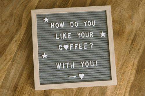 Free A cute, romantic coffee-themed message displayed on a felt letter board with decorative stars and hearts. Stock Photo