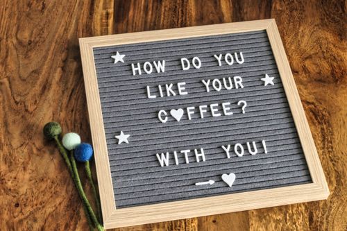 Free A romantic message on a letterboard about coffee on a warm wooden table. Stock Photo