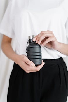 特写中的人拿着一个时尚的可折叠水瓶，倡导零浪费的生活方式