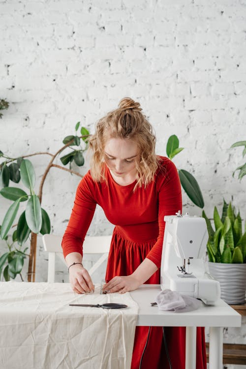 Woman in Red Long Sleeve Red Holding a White Textile