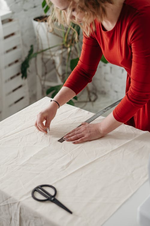 Mulher Com Vestido Vermelho De Manga Comprida Segurando Tecido Branco