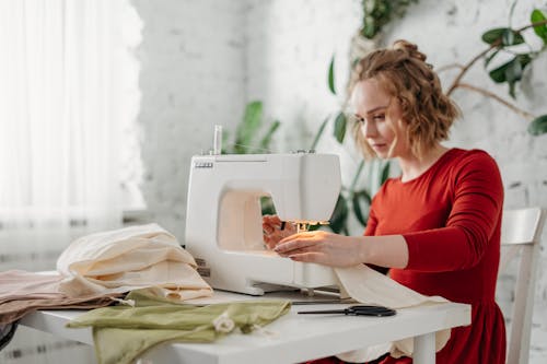 Free Woman Sewing While Sitting on Chair Stock Photo