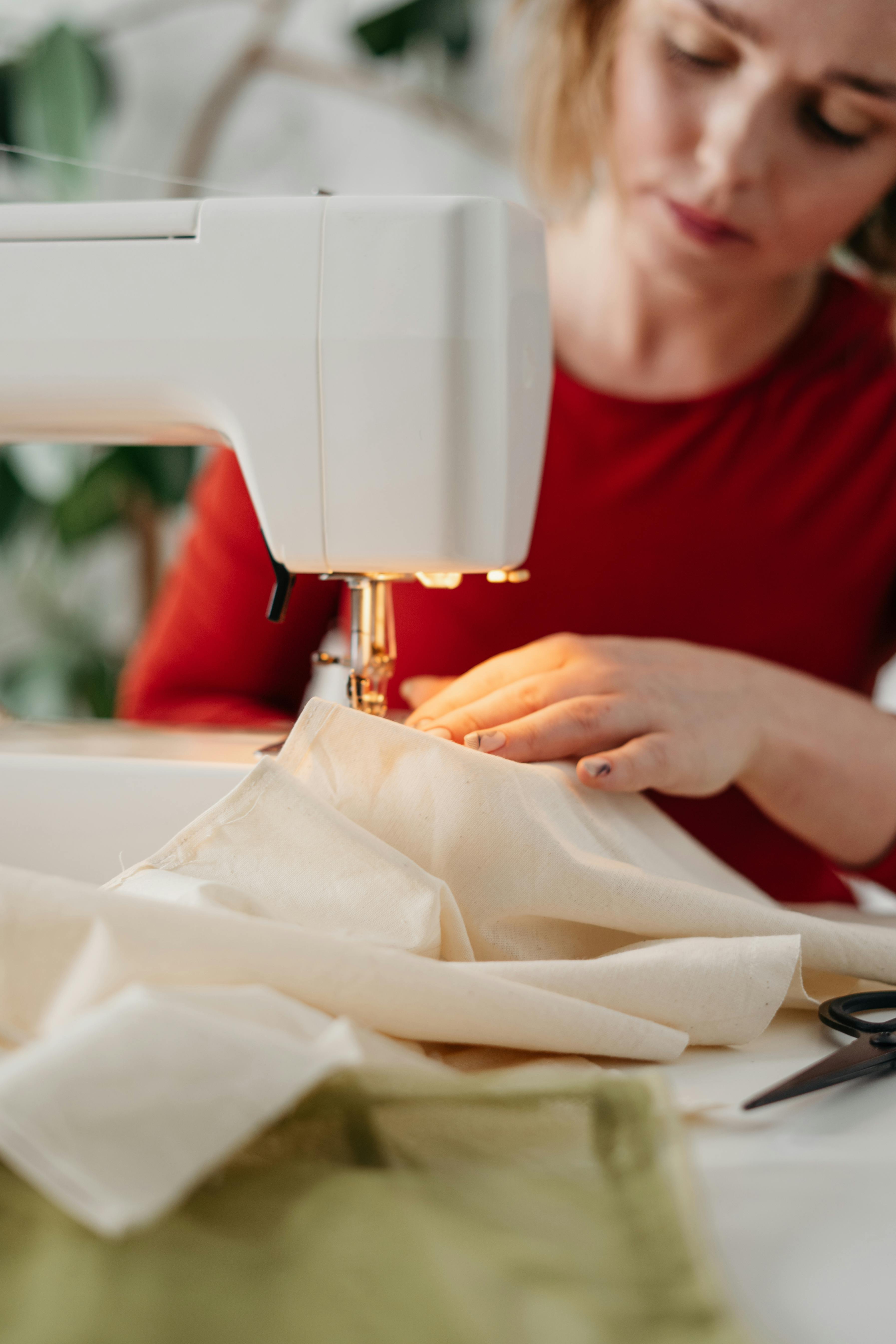 A girl is sewing on a machine. Mom shows how to work with equipment.  Close-up. Stock Photo by ©Alexeg84 314794668