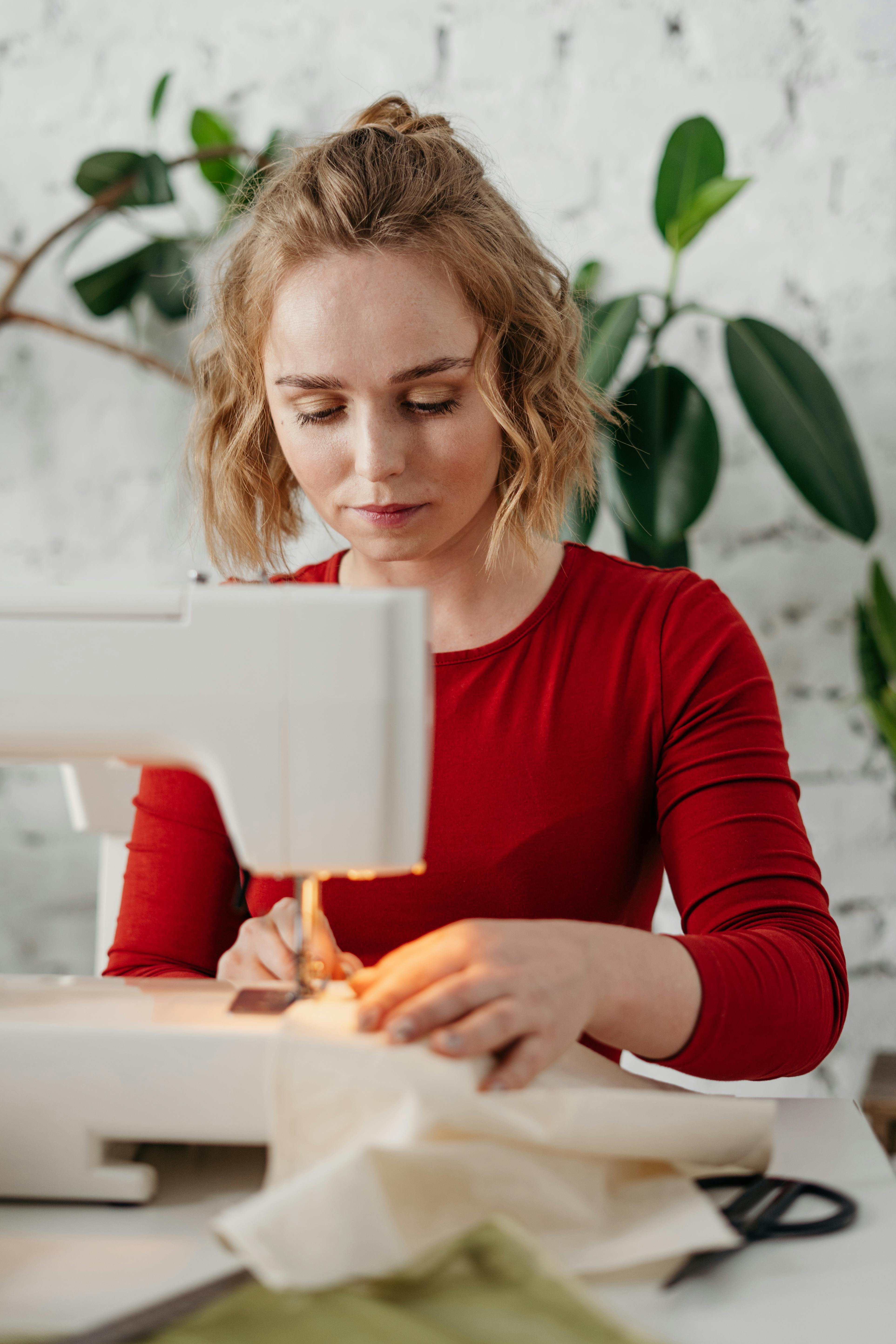 A girl is sewing on a machine. Mom shows how to work with equipment.  Close-up. Stock Photo by ©Alexeg84 314794668