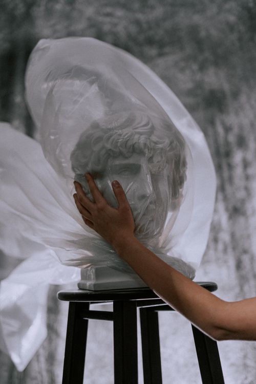Free A gypsum head sculpture wrapped in plastic, symbolizing environmental concerns and preservation. Stock Photo