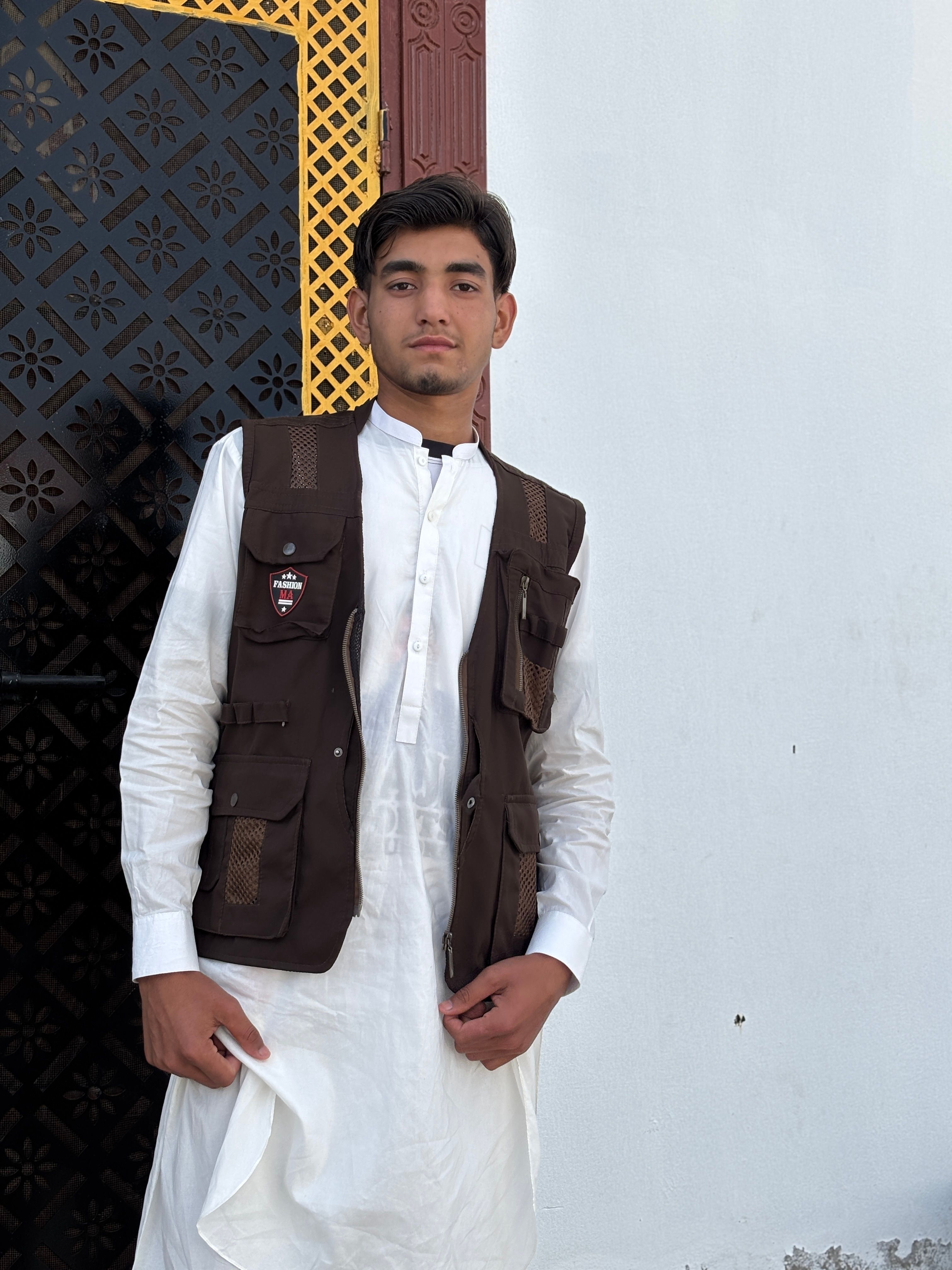 Young Adult in Traditional Outfit by Ornate Doorway