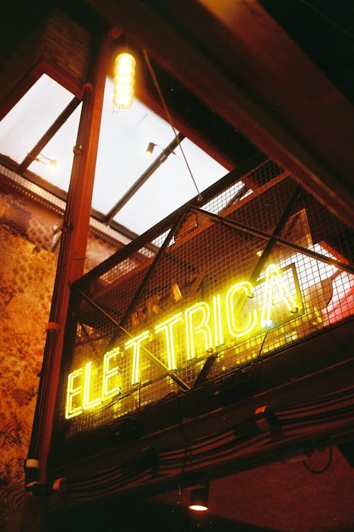 Signboard with ELETTRICA title illuminating building at night