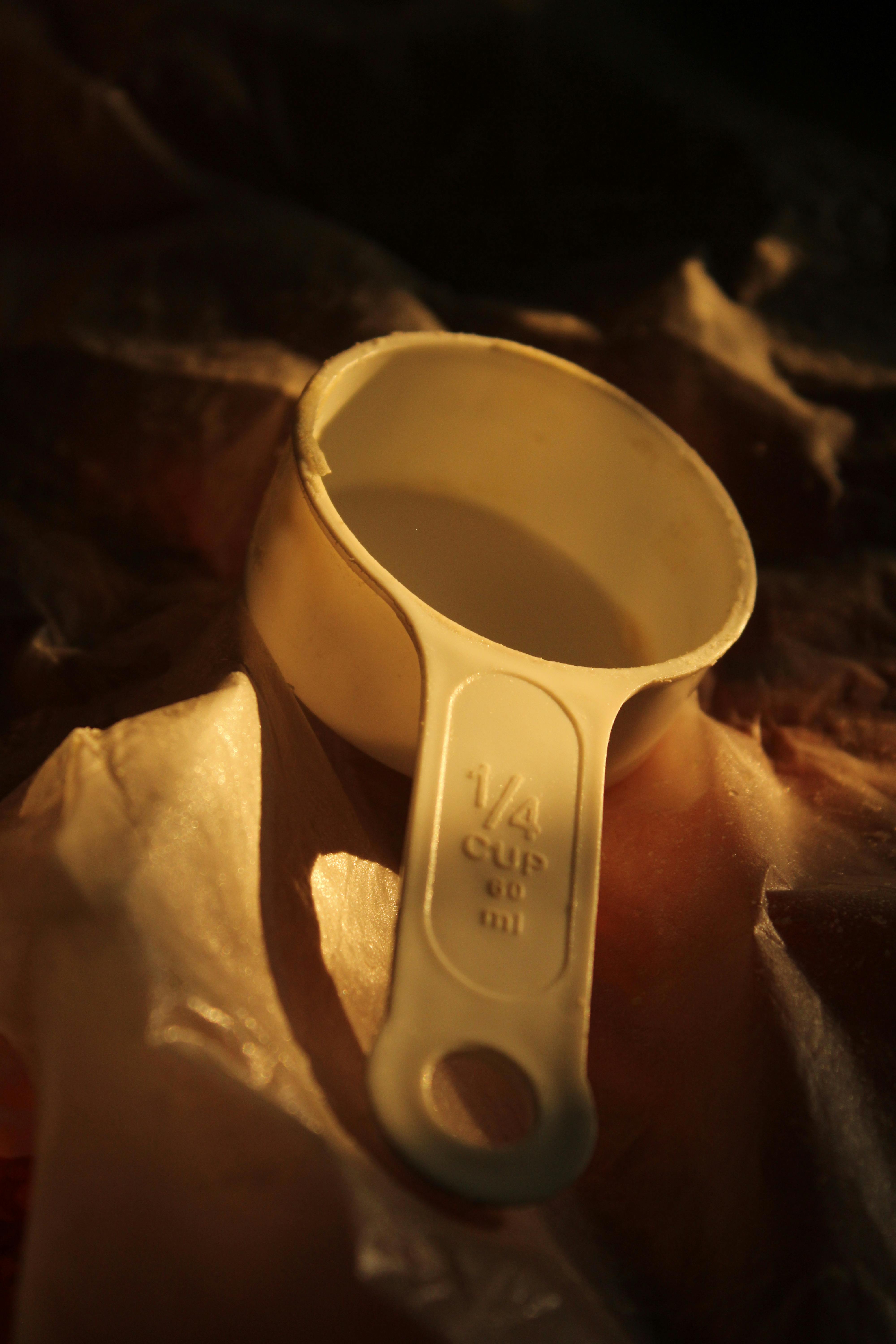 Close-up of a vintage measuring cup in warm ambient light.