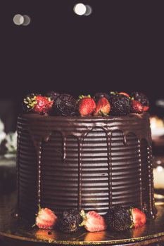 Rich chocolate cake adorned with strawberries, perfect for celebrations and dessert indulgence.