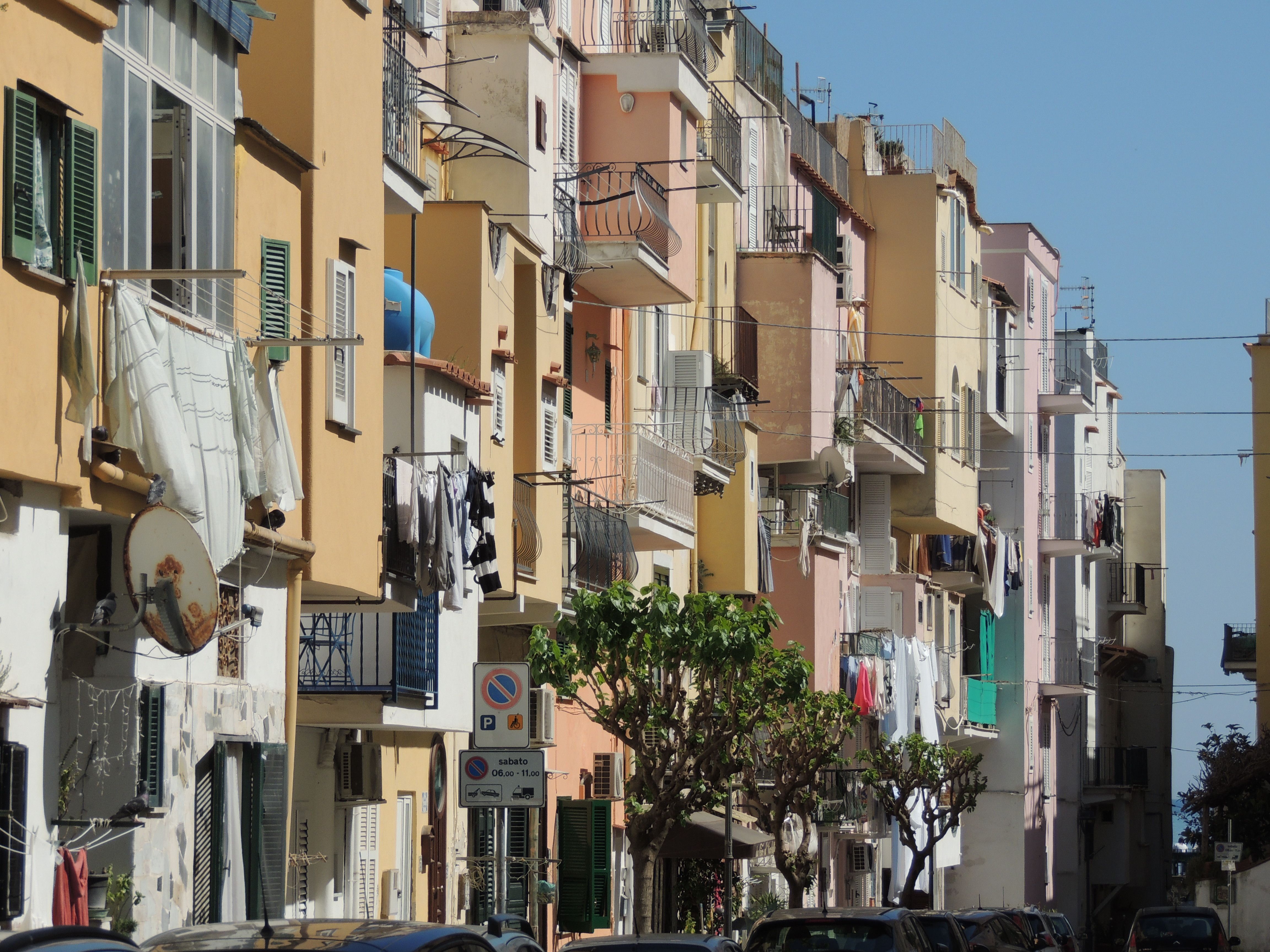 Charming street view of colorful Mediterranean-style apartment buildings with balconies.
