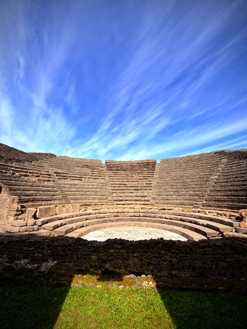 Free Explore the timeless beauty of an ancient Roman amphitheatre with a dramatic sky backdrop, captured in Pompeii. Stock Photo