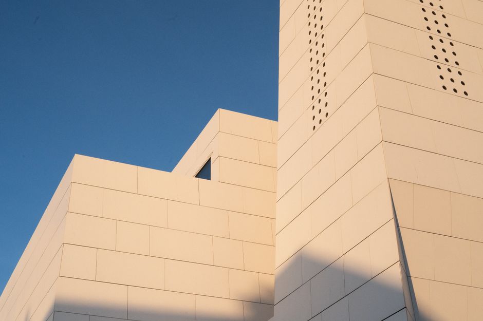 The modern exterior of the Munch Museum in Oslo, Norway, reflecting the city skyline.