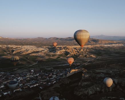 Scenic view of hot air balloons over Cappadocia's unique landscape at dawn.
