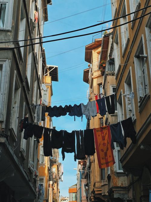 Free Colorful clothes hang on a line between traditional Istanbul buildings under a clear sky. Stock Photo