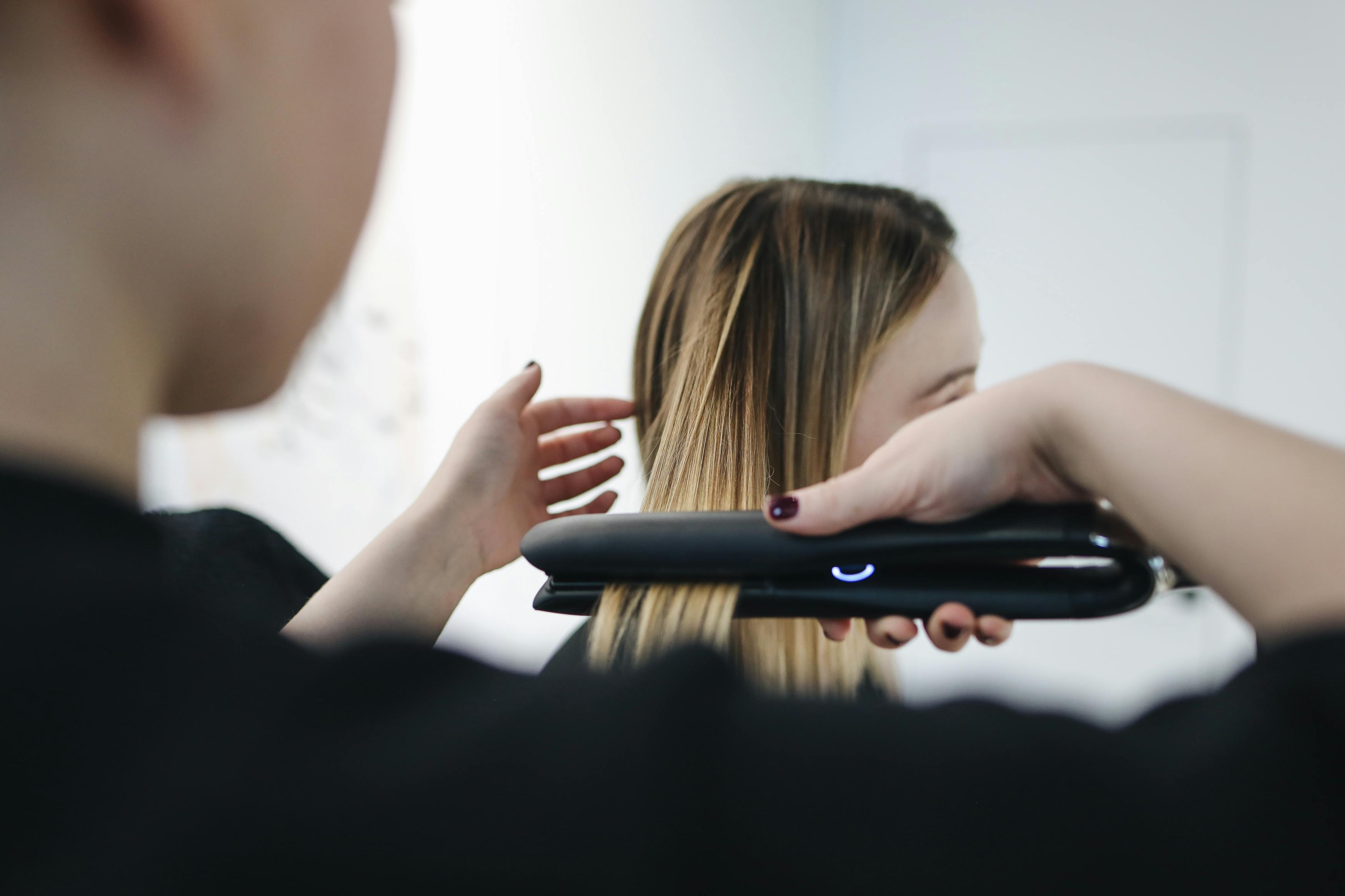 Selective Focus Photo of Person Ironing a Woman's Hair · Free Stock Photo