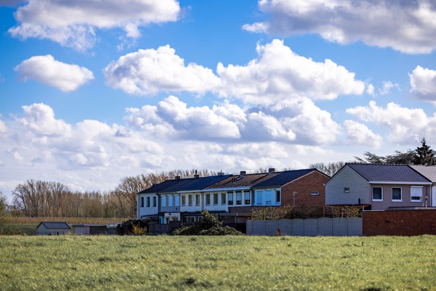 Suburban houses against a vibrant sky with clouds