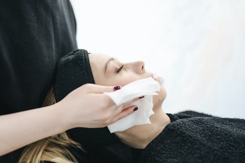 Photo of Person Using a Tissue to Dry a Woman's Face