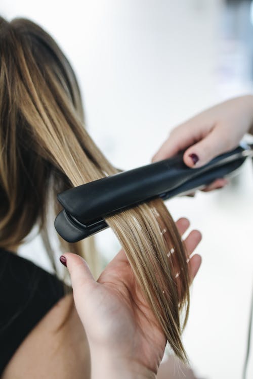 Free Person Ironing a Woman's Hair Stock Photo