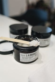 L:A Bruket sea salt scrub jar with spatula, perfect for skincare routines.