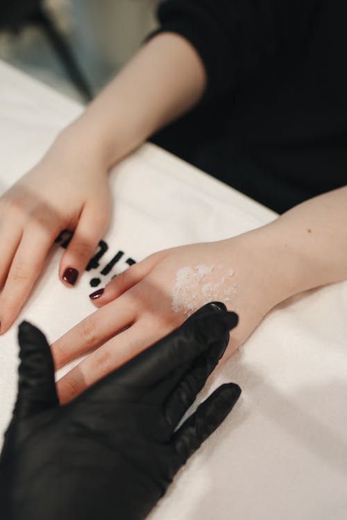 Photo De La Personne Qui Applique La Crème Sur Les Mains De La Femme