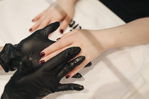 Person's Hand Wearing Black Gloves