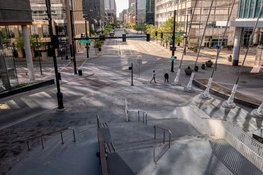 Downtown street scene with buildings and pedestrians viewed from above.